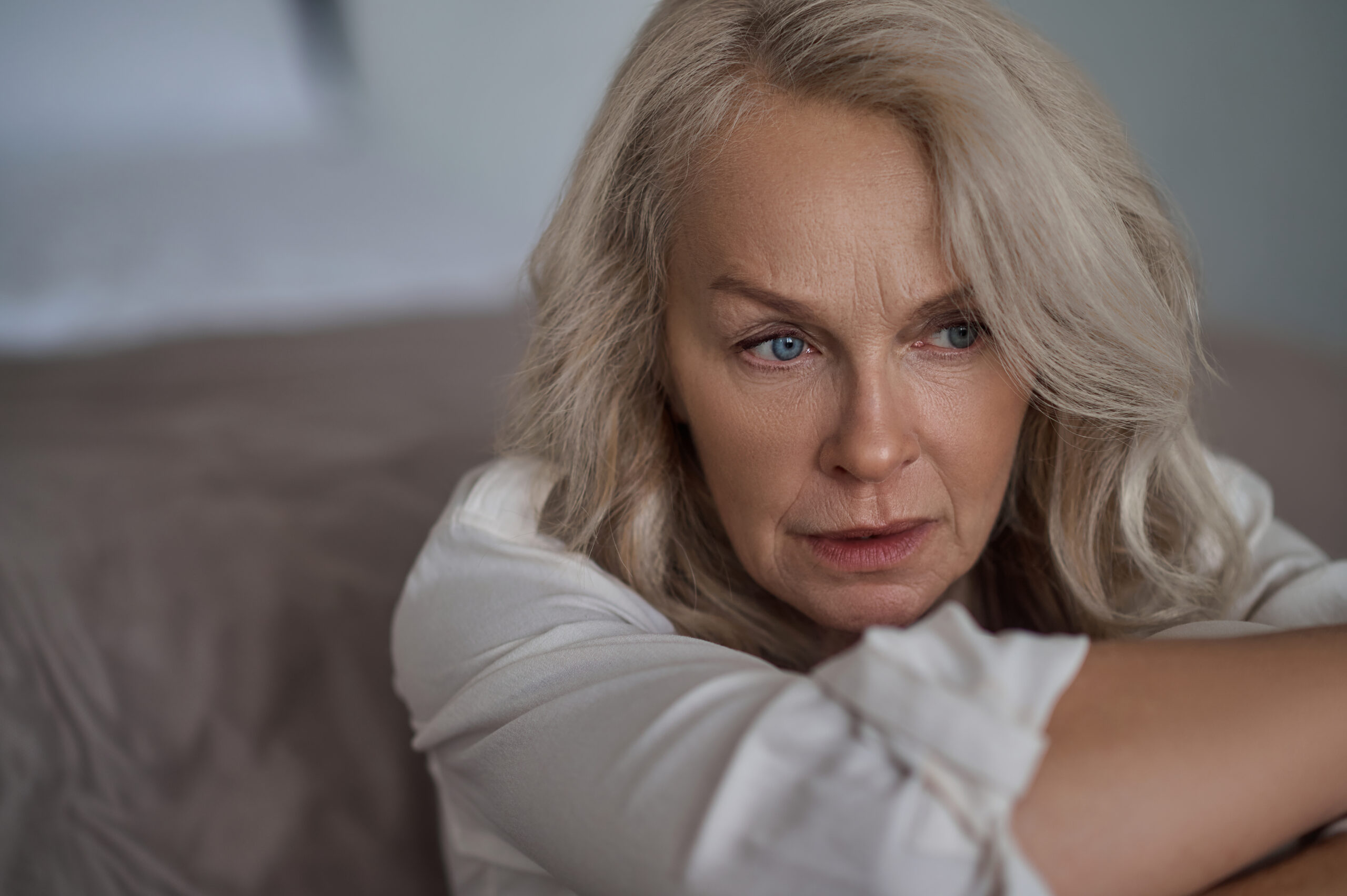 Paciente mulher de 50 anos com expressão de preocupação, representando as dificuldades relacionadas ao sangramento pós-menopausa e saúde uterina.